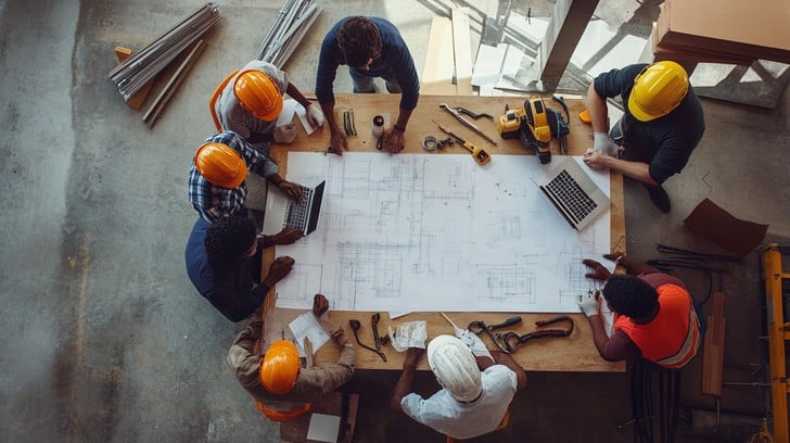 GTS Construction team discussing plans on a construction site